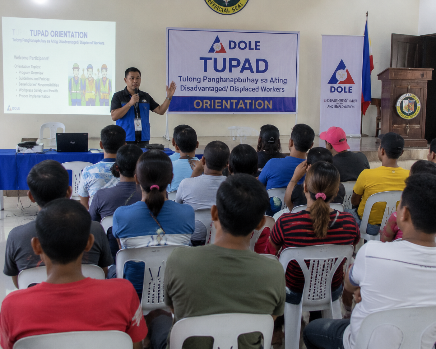 A group of Filipino TUPAD beneficiaries attentively listens to a DOLE orientation seminar